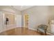This bedroom features hardwood floors, a view into the bathroom and kitchen, and a chair at 4274 Tennyson Way, Venice, FL 34293