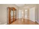 This bedroom features hardwood floors, a curio cabinet, and a view into the entry foyer at 4274 Tennyson Way, Venice, FL 34293