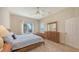 Sunlit bedroom with neutral carpet features a dresser and a large window with a view at 4274 Tennyson Way, Venice, FL 34293