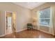 This bedroom features hardwood floors, a sitting chair, and a view into the bathroom at 4274 Tennyson Way, Venice, FL 34293