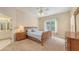 Bright bedroom features a ceiling fan, beige carpet, and natural light from the window at 4274 Tennyson Way, Venice, FL 34293