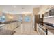 Spacious kitchen featuring granite countertops, stainless steel appliances, and tile flooring at 4274 Tennyson Way, Venice, FL 34293