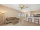 Open-concept living room with tile flooring, leather sofa, and adjacent breakfast bar at 4274 Tennyson Way, Venice, FL 34293