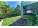 Landscaped backyard featuring tropical plants, screen patio, and well-maintained grass at 4500 Chinkapin Dr, Sarasota, FL 34232