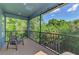 Covered and screened balcony with outdoor chairs and a view of the trees at 4500 Chinkapin Dr, Sarasota, FL 34232