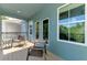 Covered and screened balcony with outdoor chairs and view of the trees at 4500 Chinkapin Dr, Sarasota, FL 34232