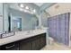 Well-lit bathroom featuring a spacious vanity, a large mirror, and a shower with a stylish curtain at 4500 Chinkapin Dr, Sarasota, FL 34232