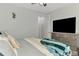 Inviting main bedroom with a large tv, wood floors and a ceiling fan at 4500 Chinkapin Dr, Sarasota, FL 34232