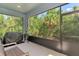 Screened patio with lush greenery outside, offering a peaceful space for outdoor relaxation at 4500 Chinkapin Dr, Sarasota, FL 34232