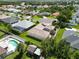 Aerial view of homes with pools, manicured lawns, and a peaceful cul-de-sac near a scenic pond at 4804 Jacaranda Heights Dr, Venice, FL 34293