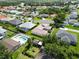An aerial shot of homes in a quiet community, some with pools, all surrounded by abundant trees and landscaping at 4804 Jacaranda Heights Dr, Venice, FL 34293