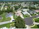 Wide aerial shot of a residential area with well-maintained homes, swimming pools, and lush landscaping at 4804 Jacaranda Heights Dr, Venice, FL 34293