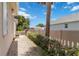 Cozy backyard with a small patio, white picket fence, and lush greenery at 4804 Jacaranda Heights Dr, Venice, FL 34293