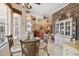 Open-concept dining area featuring stylish furniture, abundant natural light, and an eye-catching stone accent wall at 4804 Jacaranda Heights Dr, Venice, FL 34293