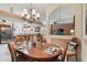 Dining room featuring a traditional dining table, decorative chandelier, and easy access to living areas at 4804 Jacaranda Heights Dr, Venice, FL 34293