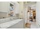 Well-lit laundry room with modern washer and dryer, plus convenient access to the kitchen at 4804 Jacaranda Heights Dr, Venice, FL 34293