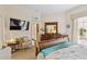 This bedroom features a TV, dresser with mirror, and chair, all contributing to a relaxing and comfortable space at 4804 Jacaranda Heights Dr, Venice, FL 34293