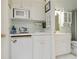 Convenient wet bar featuring a sink, microwave, and mini-fridge, perfect for entertaining guests at 4804 Jacaranda Heights Dr, Venice, FL 34293
