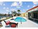 The backyard boasts a swimming pool, waterfront access, lush greenery, and comfortable seating at 4829 Commonwealth Rd, Palmetto, FL 34221