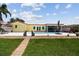 Scenic backyard view with a pristine pool, lush grass, a paved pathway, and manicured landscaping at 4829 Commonwealth Rd, Palmetto, FL 34221
