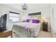 Cozy bedroom with a floral lavender quilt, two windows, and modern ceiling fan at 4829 Commonwealth Rd, Palmetto, FL 34221