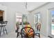 Bright dining room with a modern glass table, chairs, sliding glass door access to the patio, and a waterfront view at 4829 Commonwealth Rd, Palmetto, FL 34221