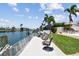 Waterfront home featuring a private dock with chairs overlooking the canal, perfect for relaxing and enjoying the view at 4829 Commonwealth Rd, Palmetto, FL 34221