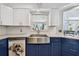 Bright kitchen with white upper cabinets, blue lower cabinets, stainless steel farmhouse sink, and subway tile backsplash at 4829 Commonwealth Rd, Palmetto, FL 34221