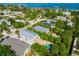 Picturesque aerial view of neighborhood featuring a community pool, lush greenery, and ocean views at 507 Spring Ave, Anna Maria, FL 34216