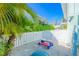 A private backyard area with a small play structure and a white fence, providing a secure play space at 507 Spring Ave, Anna Maria, FL 34216