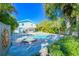 Beautiful backyard with a pool, hot tub, lush greenery, brick pavers, and a charming outdoor seating area at 507 Spring Ave, Anna Maria, FL 34216