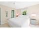 Inviting bedroom featuring a cozy bed, side tables, and a tranquil view out of the window at 507 Spring Ave, Anna Maria, FL 34216