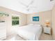 Bright bedroom with a ceiling fan, comfortable bed, and a view overlooking palm trees at 507 Spring Ave, Anna Maria, FL 34216
