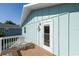 Coastal home with a blue exterior, white trim, an anchor detail, and an inviting outdoor balcony area at 507 Spring Ave, Anna Maria, FL 34216