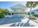 Beautiful beach house with a charming elevated porch, light blue exterior, and convenient driveway at 507 Spring Ave, Anna Maria, FL 34216