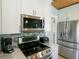 Close-up of a modern kitchen with stainless steel appliances and stylish tile backsplash at 507 Spring Ave, Anna Maria, FL 34216