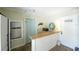 Charming kitchenette with tile countertops, stainless steel refrigerator, and a cozy breakfast bar at 507 Spring Ave, Anna Maria, FL 34216