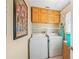 Functional laundry room with washer, dryer, and ample storage cabinets above appliances at 507 Spring Ave, Anna Maria, FL 34216