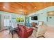 Cozy living room with wood ceiling, tile floors, comfortable seating, and bright natural light at 507 Spring Ave, Anna Maria, FL 34216