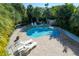 Aerial view of a private pool and spa surrounded by lush landscaping and brick pavers at 507 Spring Ave, Anna Maria, FL 34216