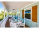 Charming porch with outdoor dining table and chairs, perfect for enjoying meals outside at 507 Spring Ave, Anna Maria, FL 34216