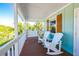 Inviting porch with comfortable seating, swing and serene views of surrounding landscape at 507 Spring Ave, Anna Maria, FL 34216