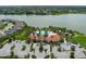 Aerial view of the community pool, clubhouse with red tile roof, parking, and landscaping near a lake and residential area at 5651 Trevesta Pl, Palmetto, FL 34221