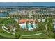 Aerial image of the community pool and clubhouse with parking, playground and manicured green spaces near lakefront homes at 5651 Trevesta Pl, Palmetto, FL 34221