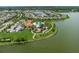 Aerial view of the community pool and clubhouse area with parking, playground, and mature trees near a lake at 5651 Trevesta Pl, Palmetto, FL 34221