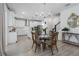 Bright dining area adjacent to the kitchen with elegant chandelier and staircase view at 5651 Trevesta Pl, Palmetto, FL 34221