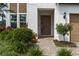 Close-up of a home's front door, landscaped pathway, and manicured shrubbery at 5651 Trevesta Pl, Palmetto, FL 34221