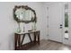 Hallway with console table, ornate mirror, and light hardwood flooring at 5651 Trevesta Pl, Palmetto, FL 34221