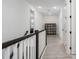 Well-lit second floor hallway with wood-look flooring, white doors, and a decorative shelving unit at 5651 Trevesta Pl, Palmetto, FL 34221