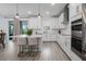 Modern kitchen with stainless steel appliances, island with breakfast bar, and white cabinets at 5651 Trevesta Pl, Palmetto, FL 34221